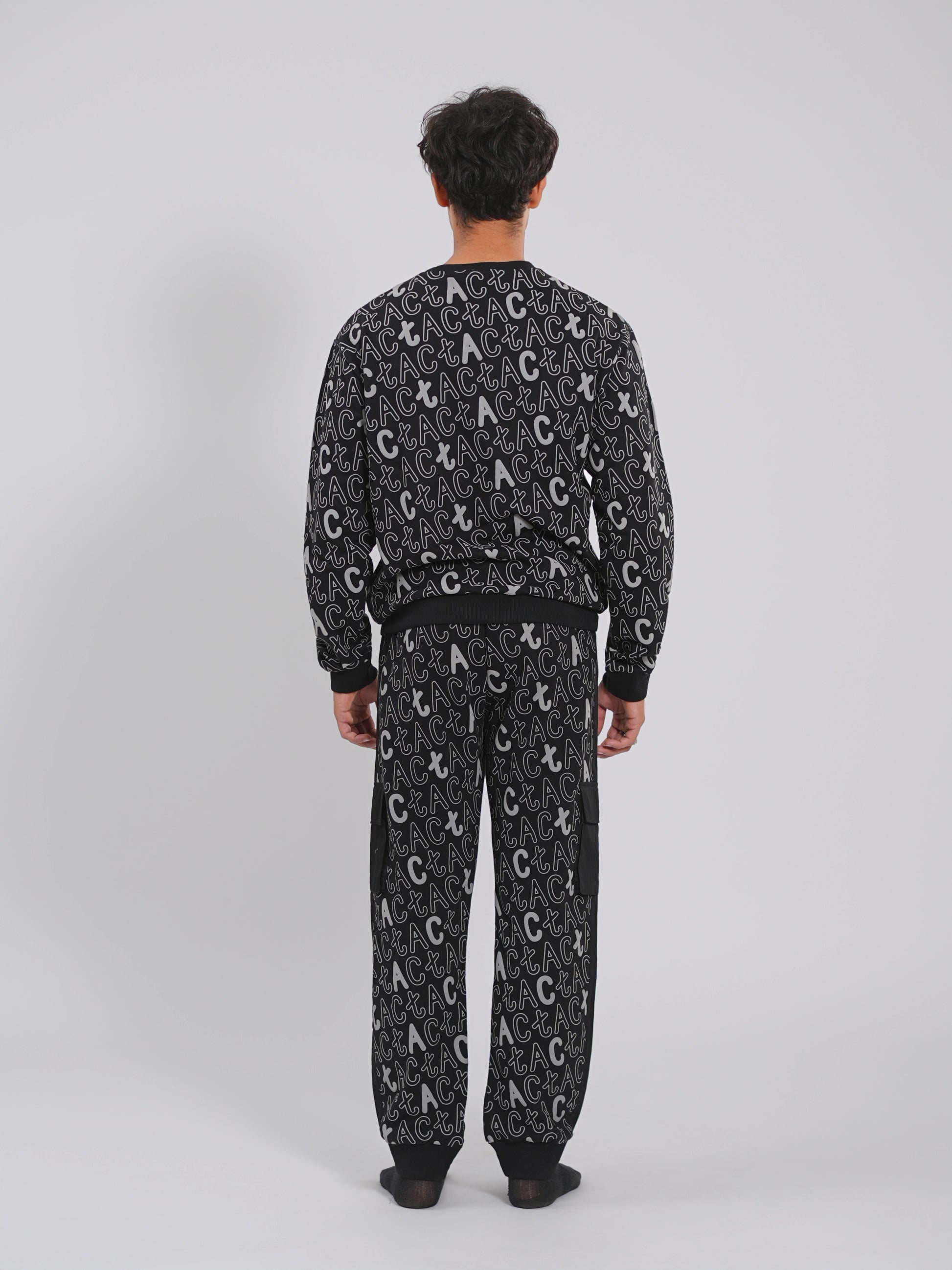 Person wearing a black patterned pajama set on a white background