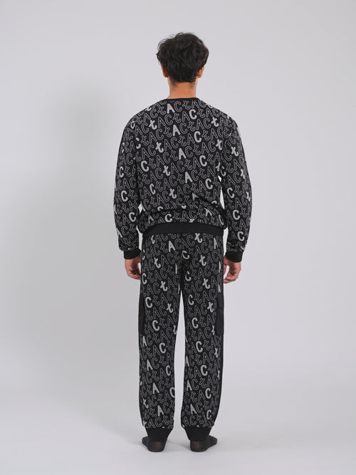 Person wearing a black patterned pajama set on a white background