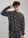 Person wearing a black sweater with white text pattern on a gray background