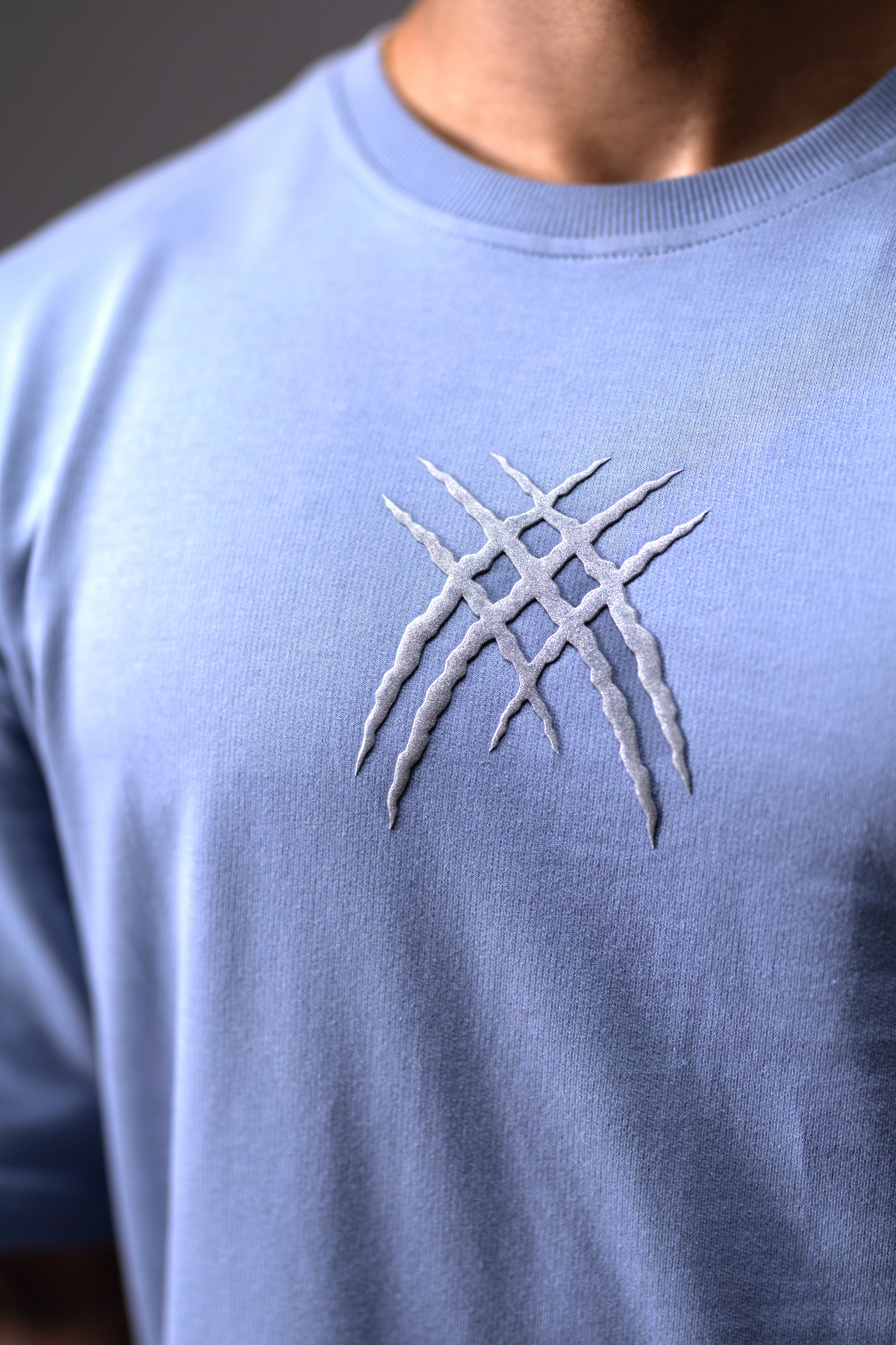 Light blue t-shirt with a white embroidered design on a dark background